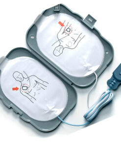 Uppvikt grå plastförpackning med två kablar och vita skyddsfilmer, illustrerade med en man som visar var elektroderna ska placeras.