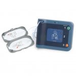 Närbild av Philips HeartStart FRx, en mörkblå och turkos hjärtstartare med två elektroder kopplade, mot vit bakgrund.