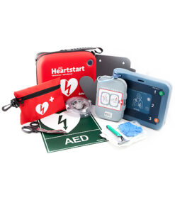 Närbild av Philips HeartStart FRx, en mörkblå och turkos hjärtstartare med två elektroder kopplade, mot vit bakgrund.